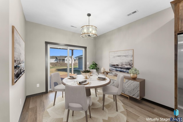 dining area with light wood-style floors, an inviting chandelier, baseboards, and visible vents