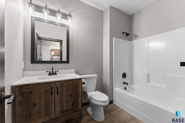 bathroom featuring washtub / shower combination, vanity, baseboards, toilet, and wood finished floors