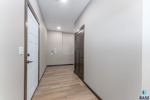 corridor featuring baseboards and light wood-style floors