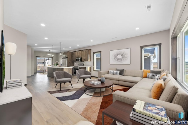living area with visible vents, recessed lighting, and light wood-style floors