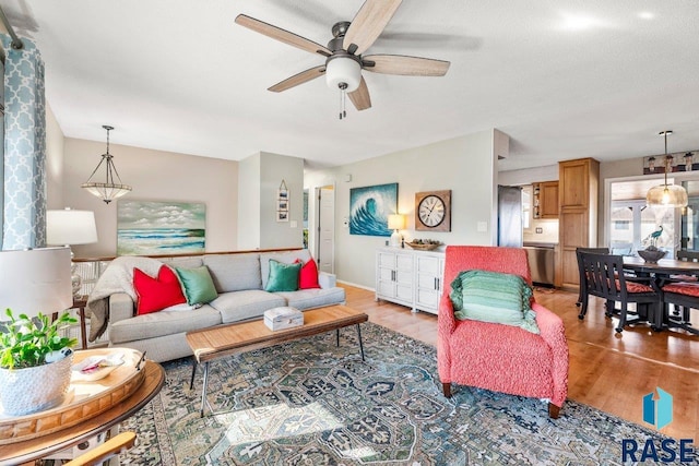 living area featuring ceiling fan and light wood-type flooring
