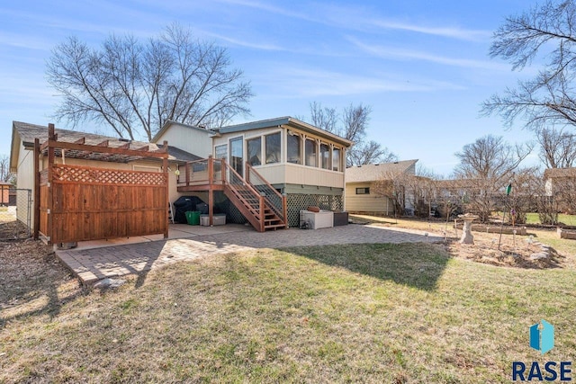 back of house featuring a patio area, stairway, a sunroom, and a lawn