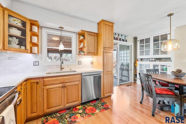 kitchen featuring pendant lighting, light wood-style flooring, open shelves, a sink, and stainless steel appliances