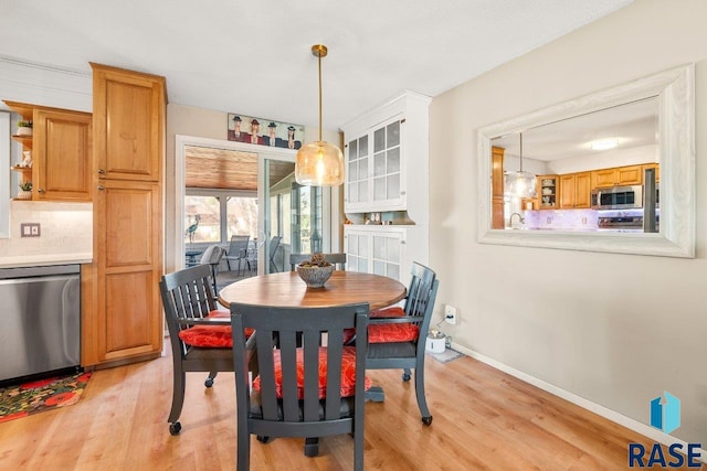 dining area featuring light wood-type flooring and baseboards