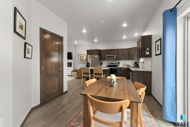 dining space featuring light wood-style floors, baseboards, and recessed lighting