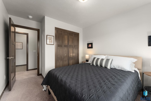 bedroom with light carpet, a closet, and baseboards