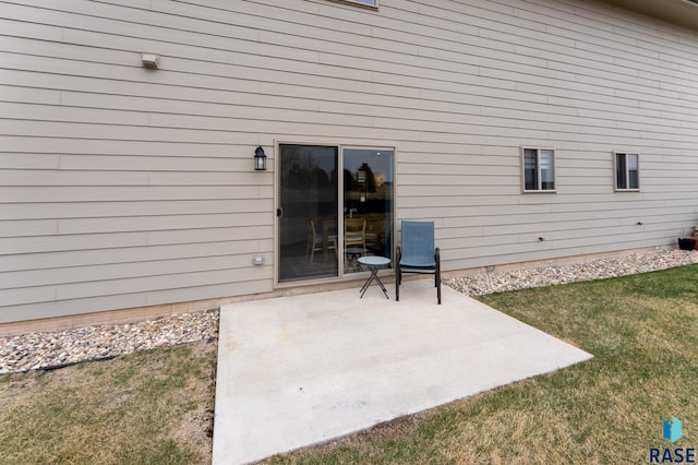 property entrance featuring a patio area and a lawn