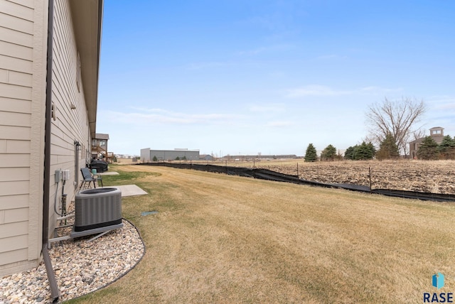 view of yard with a rural view and central air condition unit