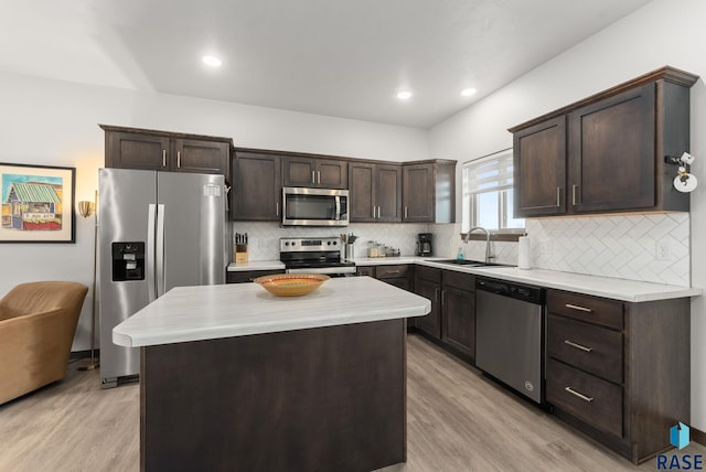 kitchen featuring light wood-style floors, a sink, dark brown cabinets, and stainless steel appliances