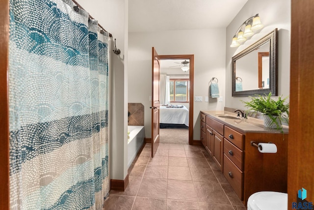 ensuite bathroom with vanity, tile patterned flooring, ensuite bathroom, toilet, and ceiling fan