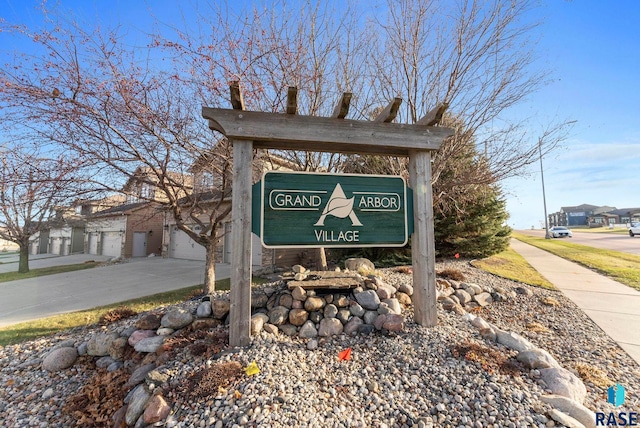 community sign featuring concrete driveway