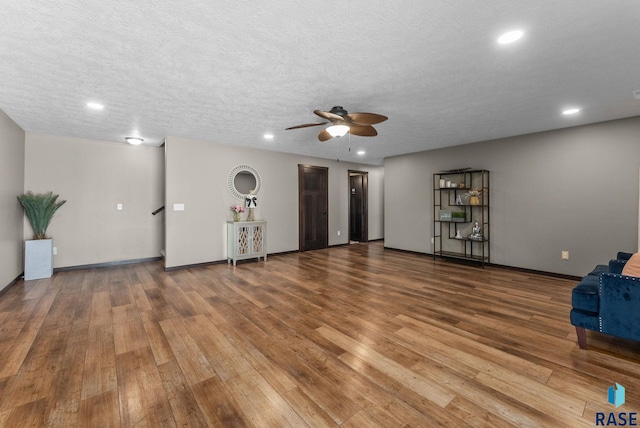 unfurnished living room featuring a textured ceiling, wood finished floors, a ceiling fan, and recessed lighting