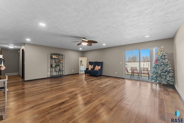 living room featuring baseboards, recessed lighting, visible vents, ceiling fan, and wood finished floors