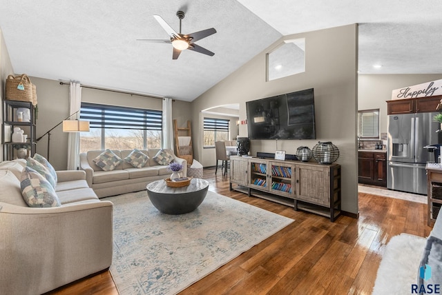 living room featuring a textured ceiling, a ceiling fan, lofted ceiling, and dark wood finished floors