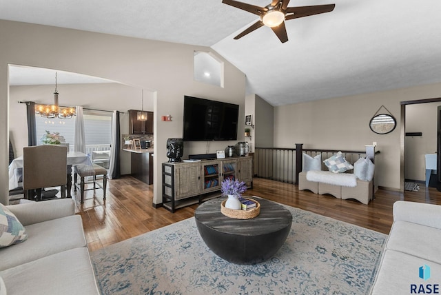 living room featuring lofted ceiling, wood finished floors, and ceiling fan with notable chandelier