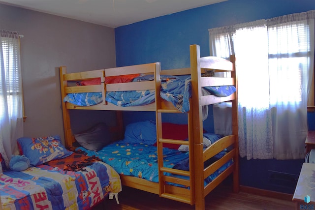 bedroom featuring wood finished floors and multiple windows