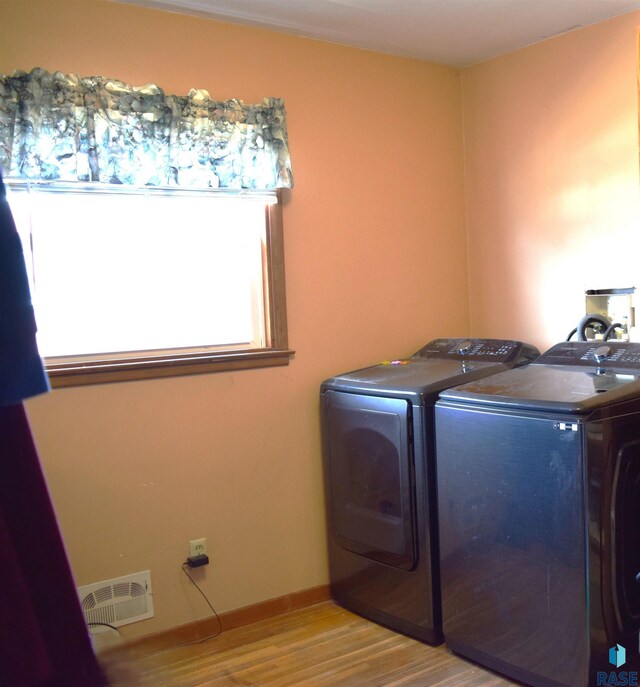 washroom with visible vents, baseboards, separate washer and dryer, laundry area, and wood finished floors