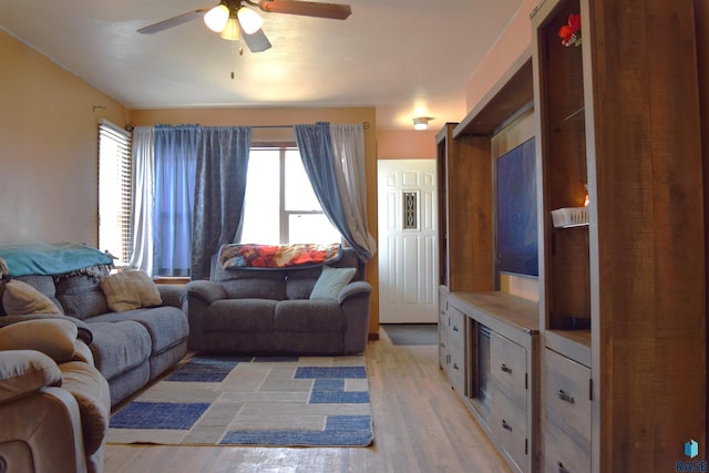 living area featuring light wood-style floors and a ceiling fan