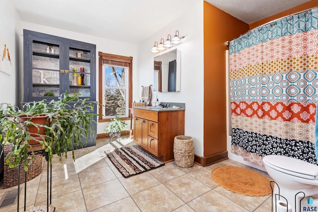 full bathroom with toilet, tile patterned flooring, baseboards, and vanity