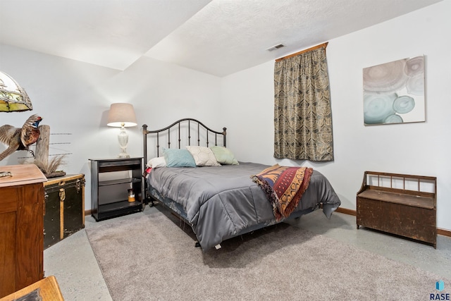 bedroom featuring visible vents, baseboards, light speckled floor, and a textured ceiling