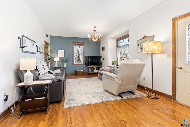 living room featuring a wealth of natural light, baseboards, an inviting chandelier, and wood finished floors