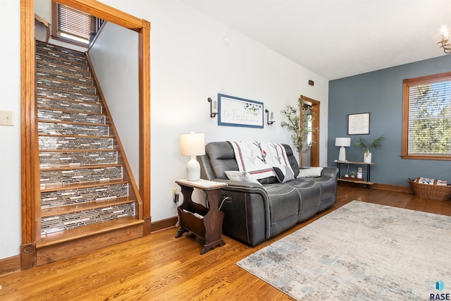 living room with stairway, baseboards, and wood finished floors