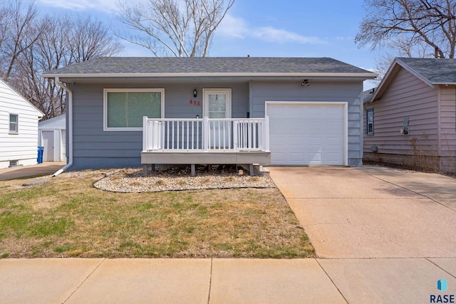 ranch-style home with concrete driveway, roof with shingles, an attached garage, a front yard, and a porch