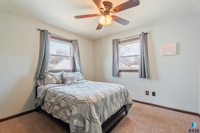 bedroom featuring multiple windows, a textured ceiling, and carpet floors