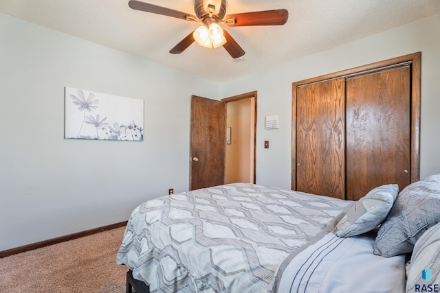 bedroom with ceiling fan, a textured ceiling, a closet, carpet flooring, and baseboards