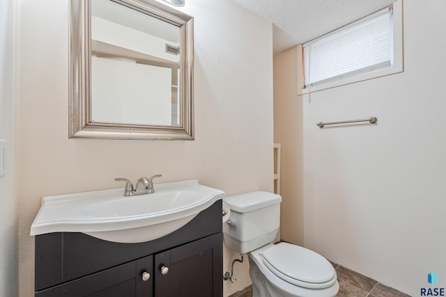 bathroom featuring vanity, tile patterned floors, a textured ceiling, toilet, and visible vents