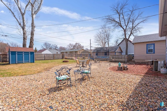 view of yard featuring an outbuilding, a shed, central air condition unit, a fenced backyard, and a trampoline