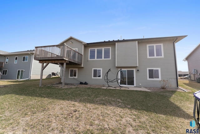 rear view of property with a wooden deck and a lawn