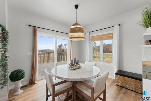dining space with plenty of natural light, visible vents, light wood-type flooring, and baseboards