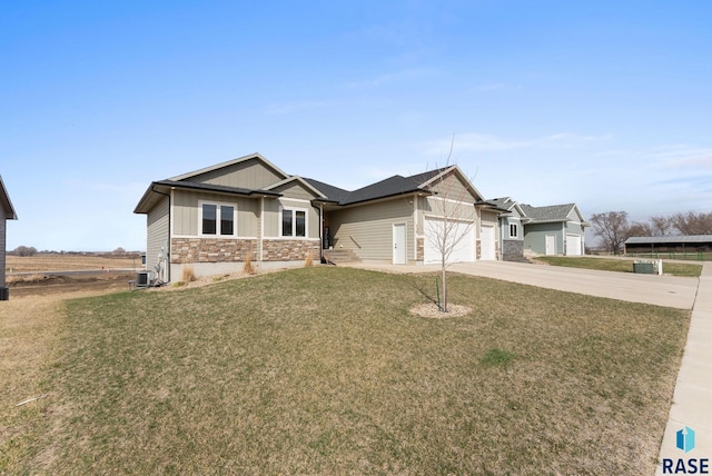 view of front of property with driveway, board and batten siding, stone siding, an attached garage, and a front lawn