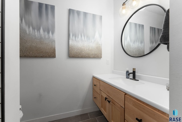bathroom featuring toilet, tile patterned floors, vanity, and baseboards
