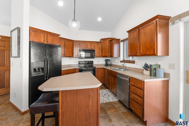 kitchen featuring a kitchen breakfast bar, a center island, light countertops, brown cabinetry, and black appliances