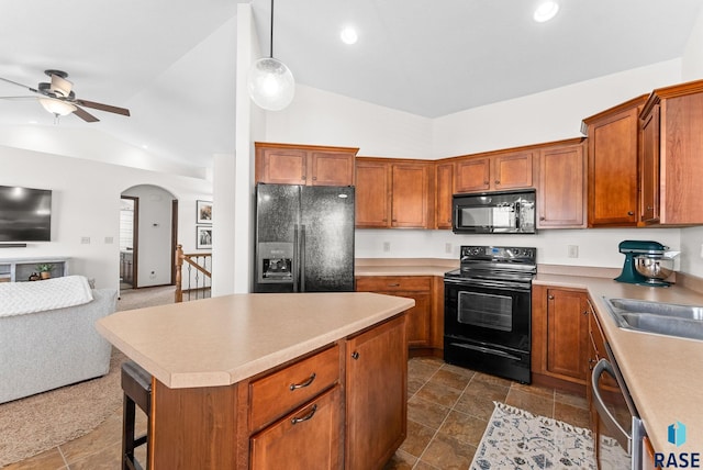 kitchen featuring open floor plan, a ceiling fan, black appliances, and brown cabinetry