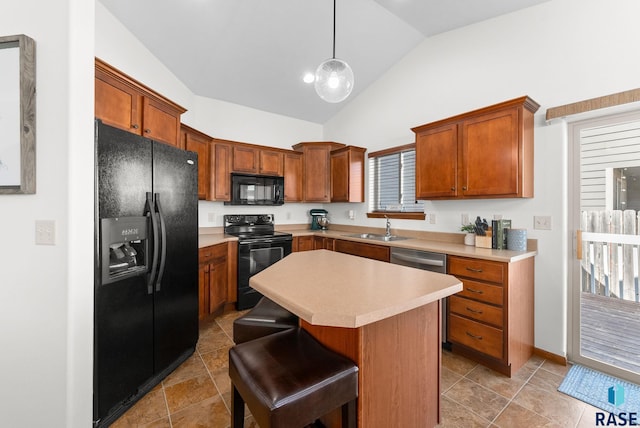 kitchen featuring a center island, a sink, light countertops, brown cabinets, and black appliances