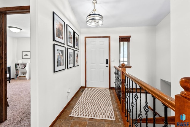 entrance foyer featuring baseboards and dark carpet