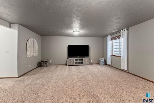 unfurnished living room featuring carpet flooring, baseboards, and a textured ceiling