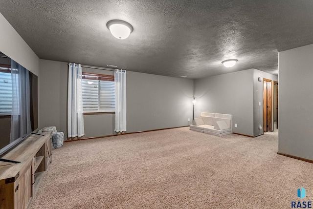 below grade area featuring a textured ceiling, baseboards, and carpet floors