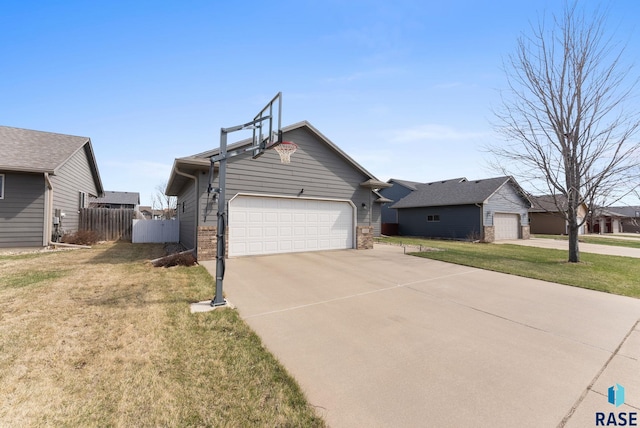 view of front of house with concrete driveway, a garage, fence, and a front lawn