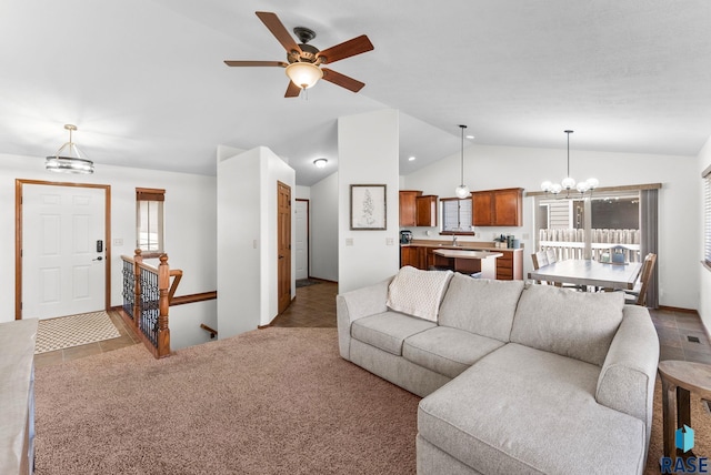 living area with a wealth of natural light, carpet, ceiling fan with notable chandelier, and vaulted ceiling