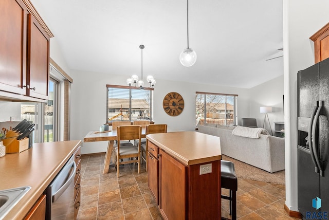 kitchen featuring black fridge, dishwasher, light countertops, and plenty of natural light