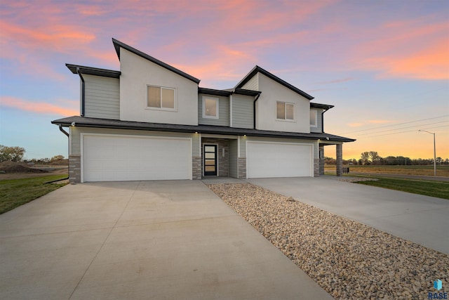 contemporary home with a garage, stone siding, and concrete driveway