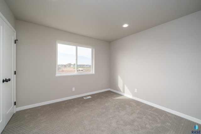 carpeted spare room featuring visible vents, baseboards, and recessed lighting
