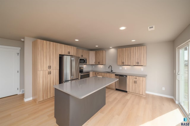 kitchen with recessed lighting, light wood finished floors, light brown cabinets, and stainless steel appliances