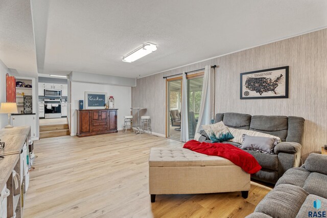 1200 Crestview Dr, Vermillion, SD 57069 - living area with light wood finished floors, wallpapered walls, and a textured ceiling