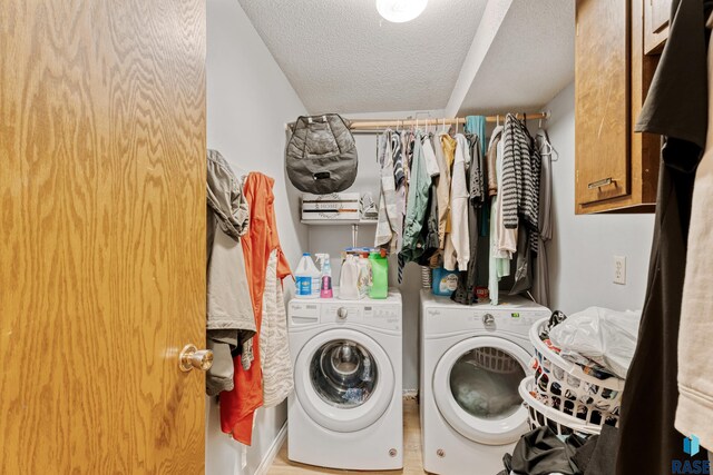 1200 Crestview Dr, Vermillion, SD 57069 - laundry room with a textured ceiling, washing machine and dryer, cabinet space, and wood finished floors