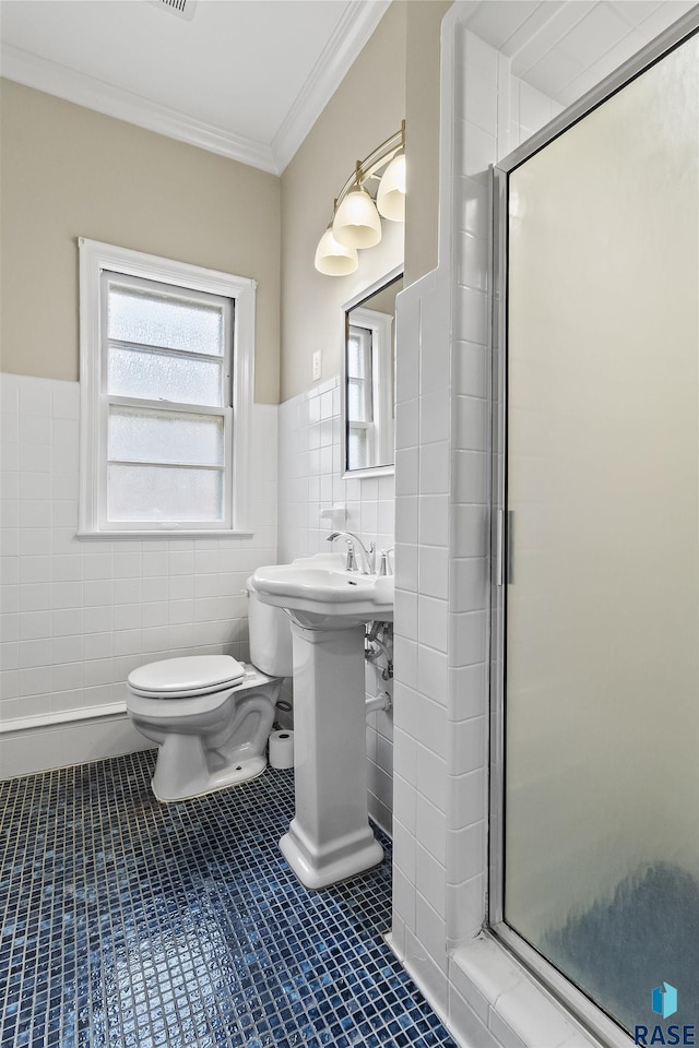 1205 Douglas Ave, Yankton, SD 57078 - full bathroom with a stall shower, crown molding, toilet, a wainscoted wall, and tile walls